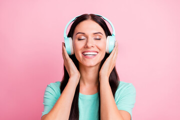 Portrait of young beautiful excited smiling positive girl in headphones listening music isolated on...