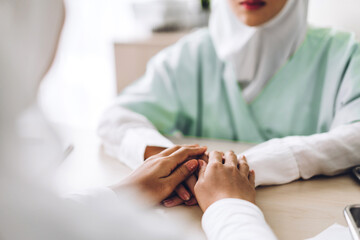 Muslim asian woman doctor service help support discussing and consulting talk to muslim woman patient and holding hand at meeting health medical care express trust concept in hospital.healthcare