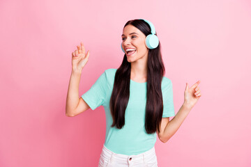 Photo of young beautiful lovely excited smiling cheerful girl in headphones dancing isolated on pink color background