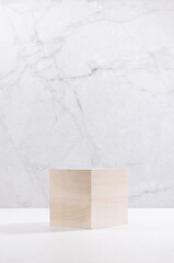 Wooden cube as podium on white wood board and grey plaster wall, showcase for cosmetics product...