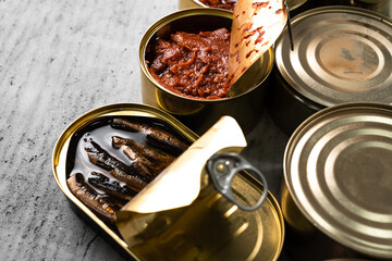 Many cans with conserved fish on wooden table