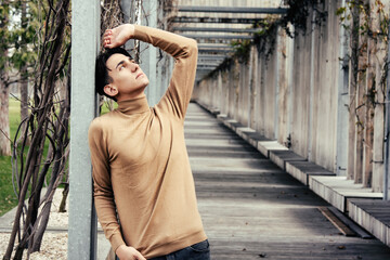 Young handsome guy posing at the camera. Male student pondering business problem solution schemes....
