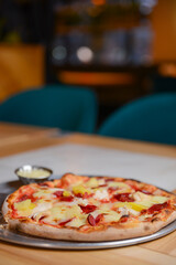 Margherita Pizza served in restaurant or pizzeria. Photo with blurred background. Traditional Italian cuisine concept.
