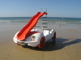 Funny pedal boat in shape of a car on a beach 