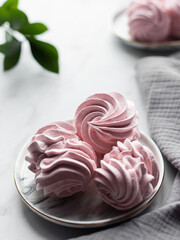 Strawberry marshmallows on a plate. On a light background