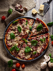 Delicious Italian pizza with mushrooms is served on a wooden table.