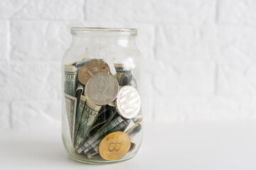 Bitcoins bronze golden coin in the glass jar on white wooden table. Set of cryptocurrencies with a...