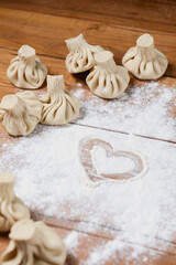 Khinkali in shape of a heart on a wooden table. Valentines Day concept, love for food.
