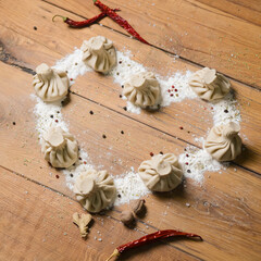 Khinkali in shape of a heart on a wooden table. Valentines Day concept, love for food.
