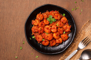 Top view spicy hot Bengali Prawn roast , shrimp masala fish curry. Indian food. Flat lay of fish fry red chili, curry leaf. Asian cuisine, Kerala fish, Goan fish curry clay pot. Grilled tiger shrimps