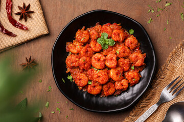 Top view spicy hot Bengali Prawn roast , shrimp masala fish curry. Indian food. Flat lay of fish fry red chili, curry leaf. Asian cuisine, Kerala fish, Goan fish curry clay pot. Grilled tiger shrimps