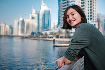 Fototapeta premium Happy young female traveler in the big city of Dubai, UAE