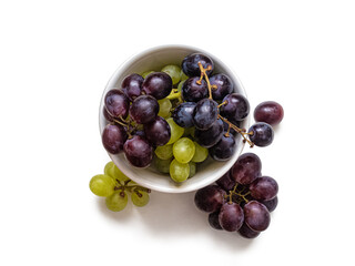 Top view of a white porcelain cup filled with red and white grapes