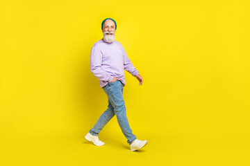 Fototapeta na wymiar Full length body size photo of smiling elder man wearing stylish clothes going forward isolated on bright yellow color background