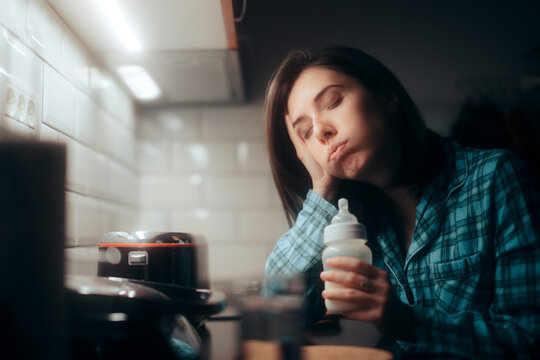 Tired Mother Holding A Milk Baby Bottle At Night