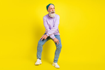 Fototapeta premium Photo of funky cheerful age gentleman wear violet sweater headwear smiling dancing isolated yellow color background