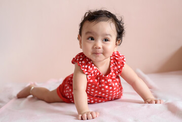 Portrait of a cute happy little Asian baby girl wearing red dress looking out, baby expression concept