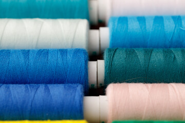 Close up of colored thread coils, thread spools background