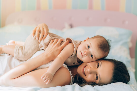 Young Mother Hugs Her Mixed Race Child. Child Adoption And In Vitro Fertilization IVF . Asian Baby And Indian Mom Lying On The Bed