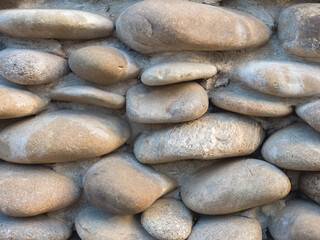 A close-up pebble wall. The background is made of stone.