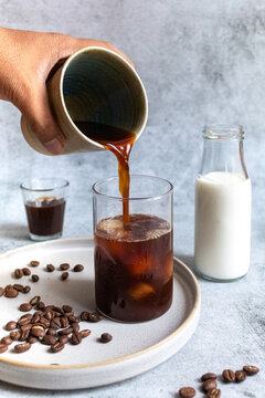 person pouring milk in coffee decoction - morning coffee