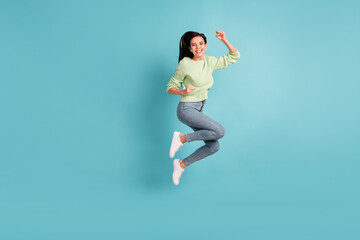 Full body photo of delighted person jumping fists up celebrate toothy smile isolated on blue color background