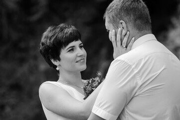 The bride and groom stand against the background of a waterfall. Newlyweds on the background of a waterfall