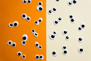 A bunch of toy eyes on an airtight two-color background split in half