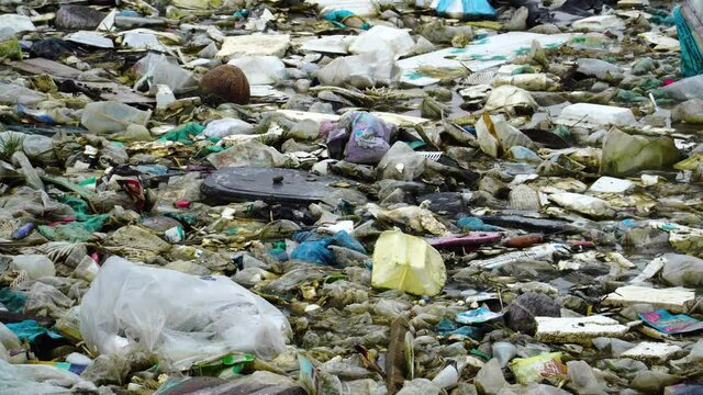 Tilt-up on garbage trash leftover on ground by river bank