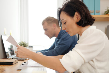 Fototapeta premium Team of young business people proofreading and checking project documents and reports