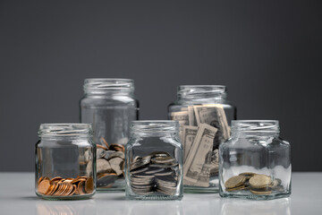 Coins and dollar bill in a glass jar, Money management, Personal Financial concept.