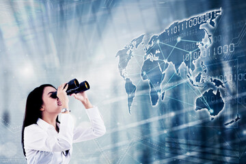 Businesswoman use binoculars to look at world map