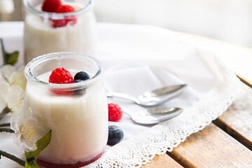 Greek yogurt with raspberries and blueberries in glass jars