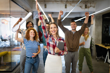 Group of successful happy business people in office celebrating profits