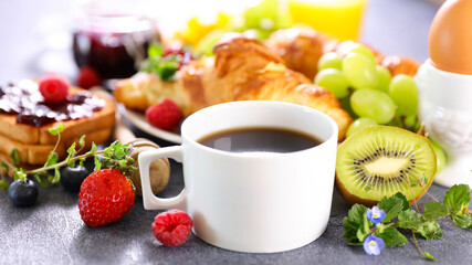 coffee cup with croissants and fruits