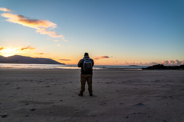 Man standing at Kiltoorish bay beach between Ardara and Portnoo in Donegal - Ireland.