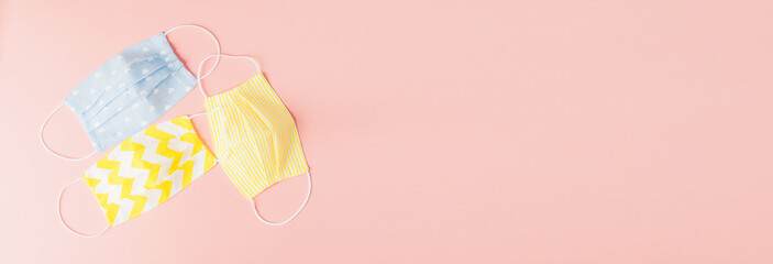 Eco-friendly reusable fabric safety mask on a pink background. Homemade breathing mask, protection against corona virus