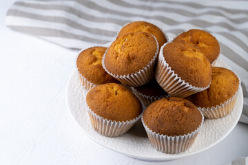 Biscuit muffins close-up. Sweet pastries. Party treat. Dessert on white table - homemade muffins. Portioned cupcakes. Simple muffin