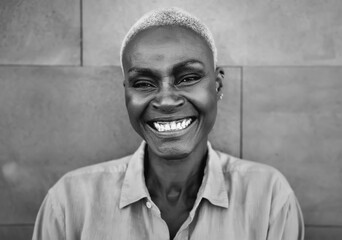 Happy Afro woman portrait - African senior having fun smiling in front of camera - Black and white editing