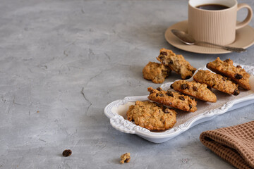 Fragrant oatmeal biscuits on a plate with openwork edges on a gray table