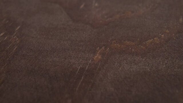 Wooden texture of a dark brown board close-up. Detailed abstract dark background. Macro. Dolly Shot