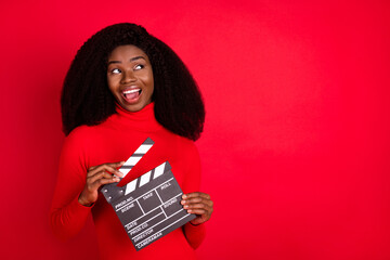 Photo of cheerful dark skin girl open mouth look interested empty space isolated on red color...