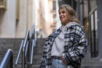 Pretty young woman wearing jeans and plaid jacket