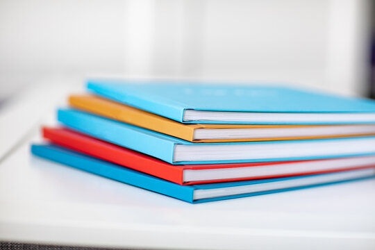 pyramid of multicolored books or photo albums. Place for the inscription. selling photographer's services or printing.