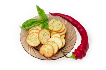 Spicy rusks with pesto sauce flavor, basil on saucer, chili