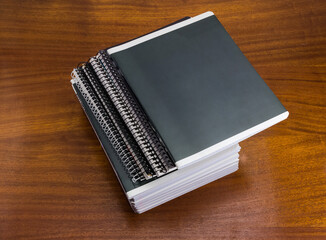 Different thick school exercise books stack on table, top view