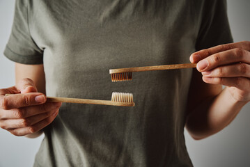 Woman hold bamboo toothbrushes, close up