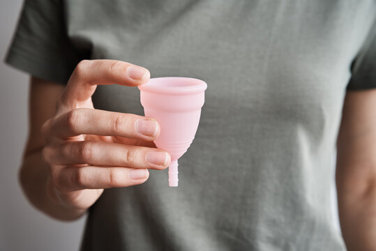 Woman holds menstrual cup in hands