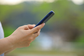 Asian woman using smartphone outdoors