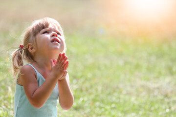 little girl praying in nature